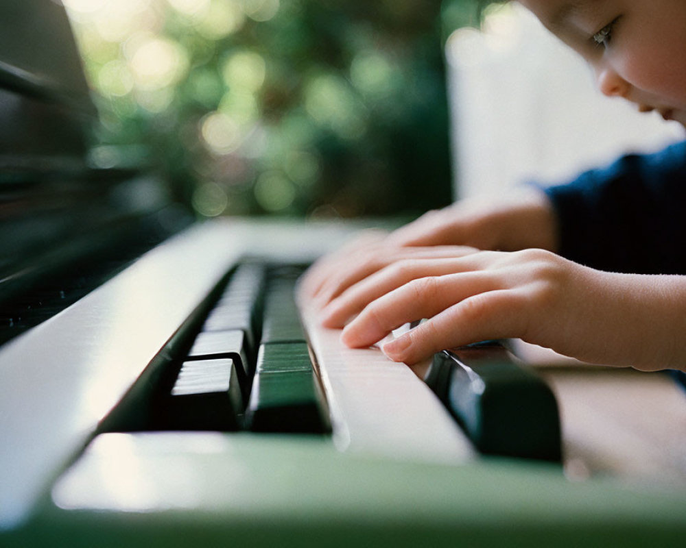 Child's hands playing piano keys in close-up shot