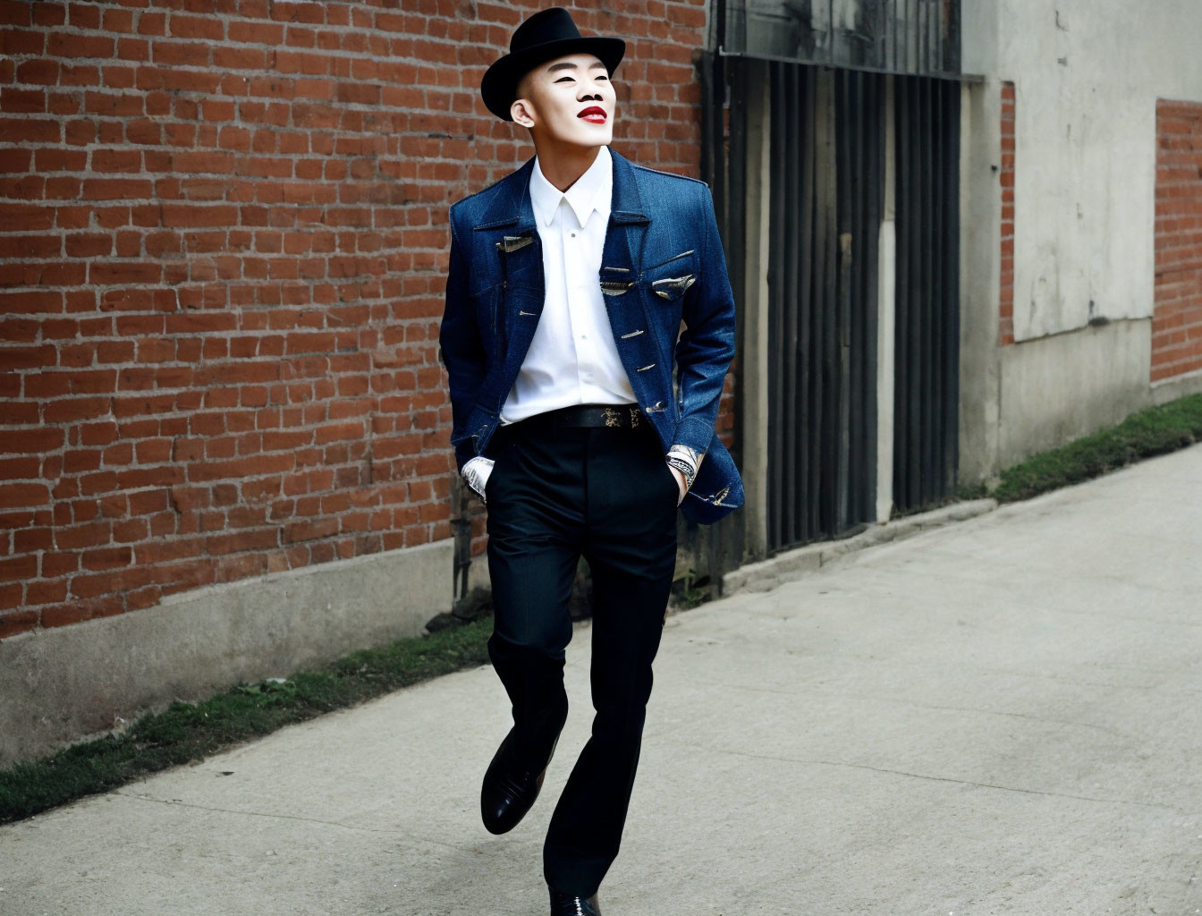 Confident person in denim jacket and fedora hat on urban street