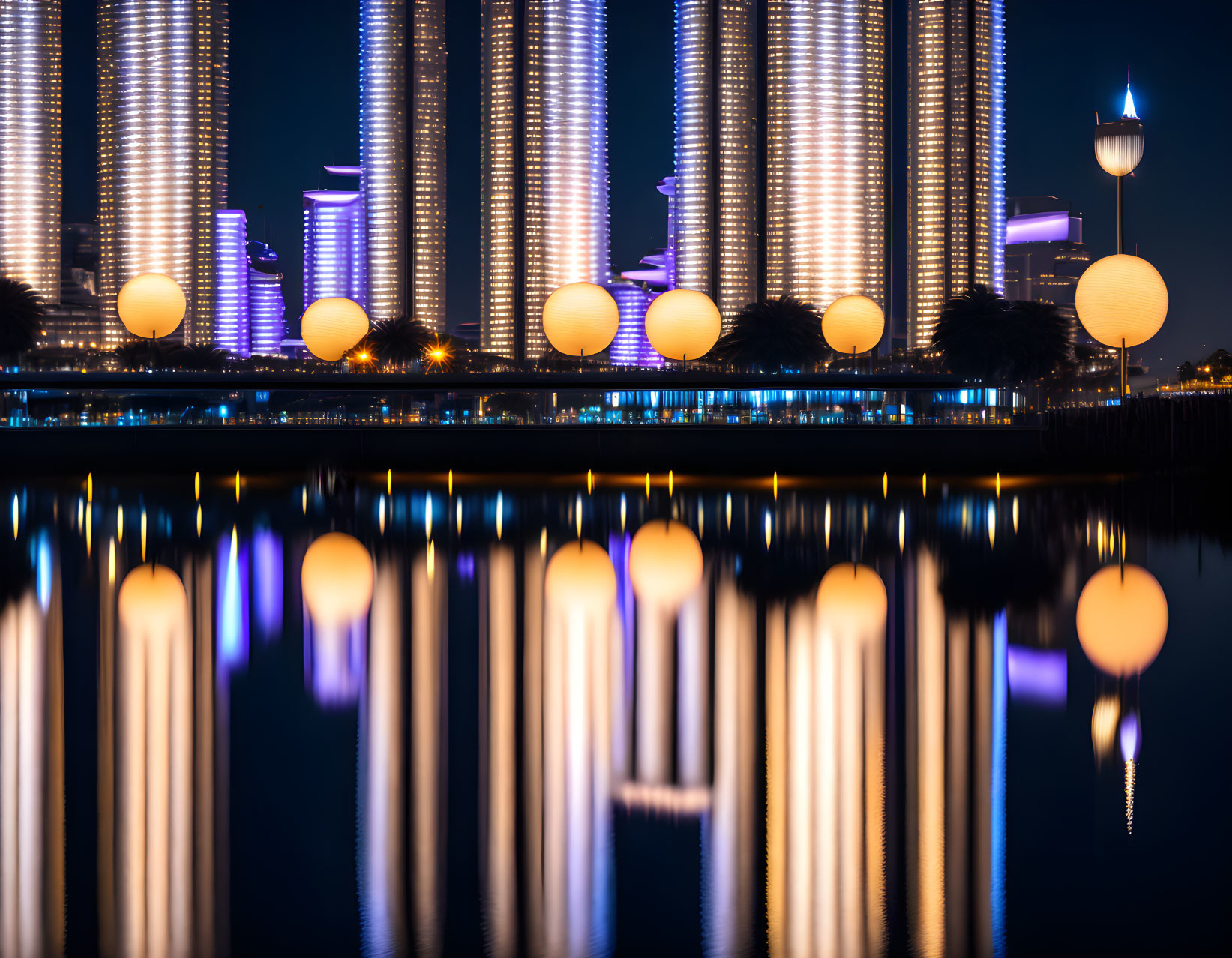 Glowing orb lights on modern skyscrapers reflected in twilight on water.