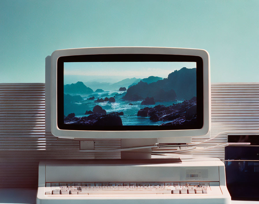 Vintage Computer Displaying Coastal Landscape Against Blue Sky