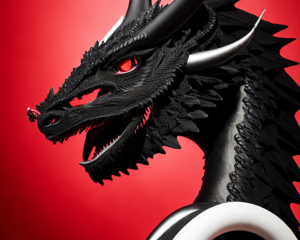 Detailed Black Dragon Model with Red Eyes and Sharp Horns on Red Background