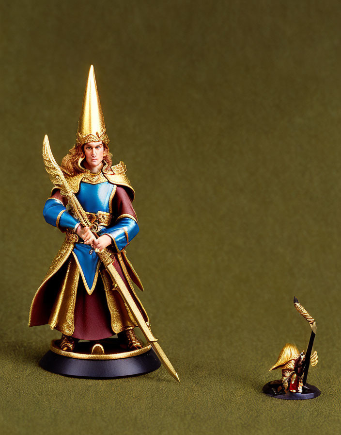 Golden armored knight figurine with blue and maroon cloak and spear next to miniature version