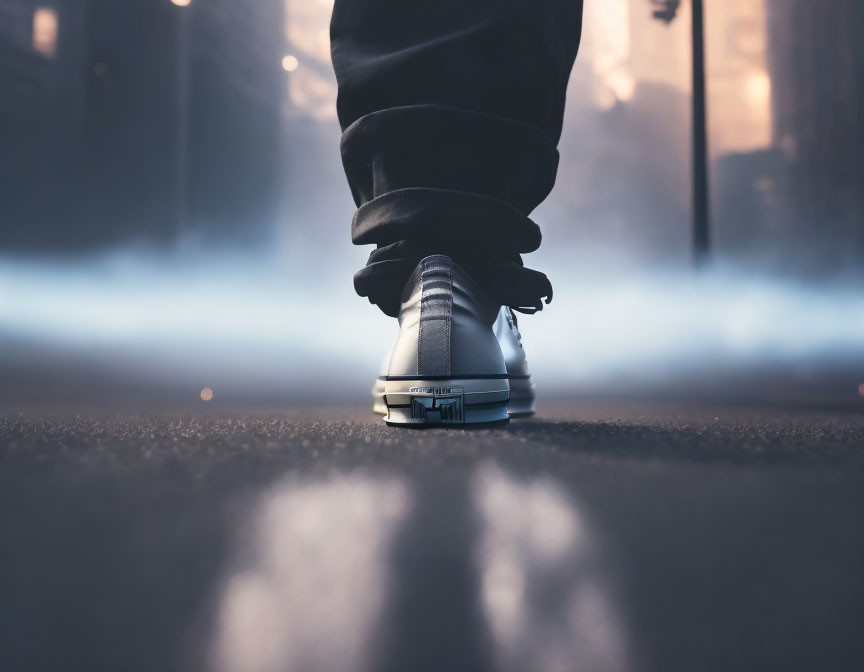 Person in sneaker stepping on urban street with misty background