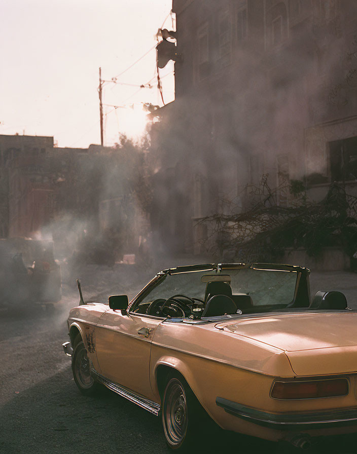 Classic Convertible Car Parked on City Street with Sunlight and Smoke Filtered Through.