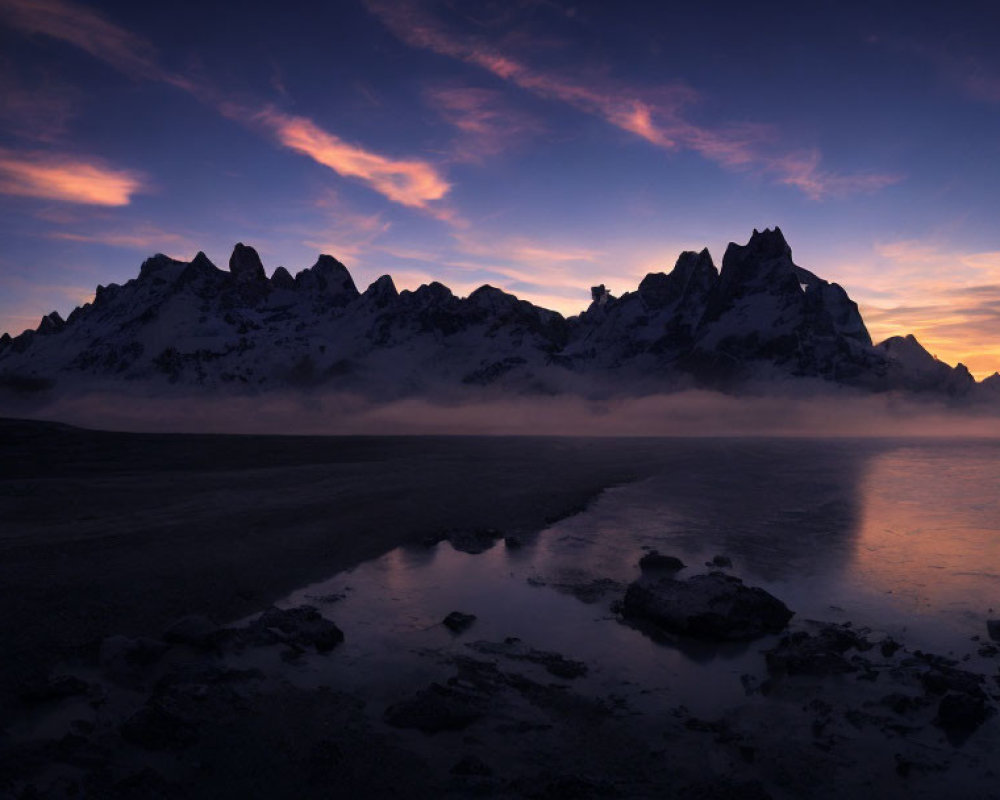 Mountain Range Silhouetted at Twilight Over Reflective Water