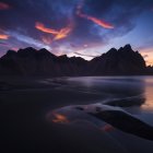 Mountain Range Silhouetted at Twilight Over Reflective Water