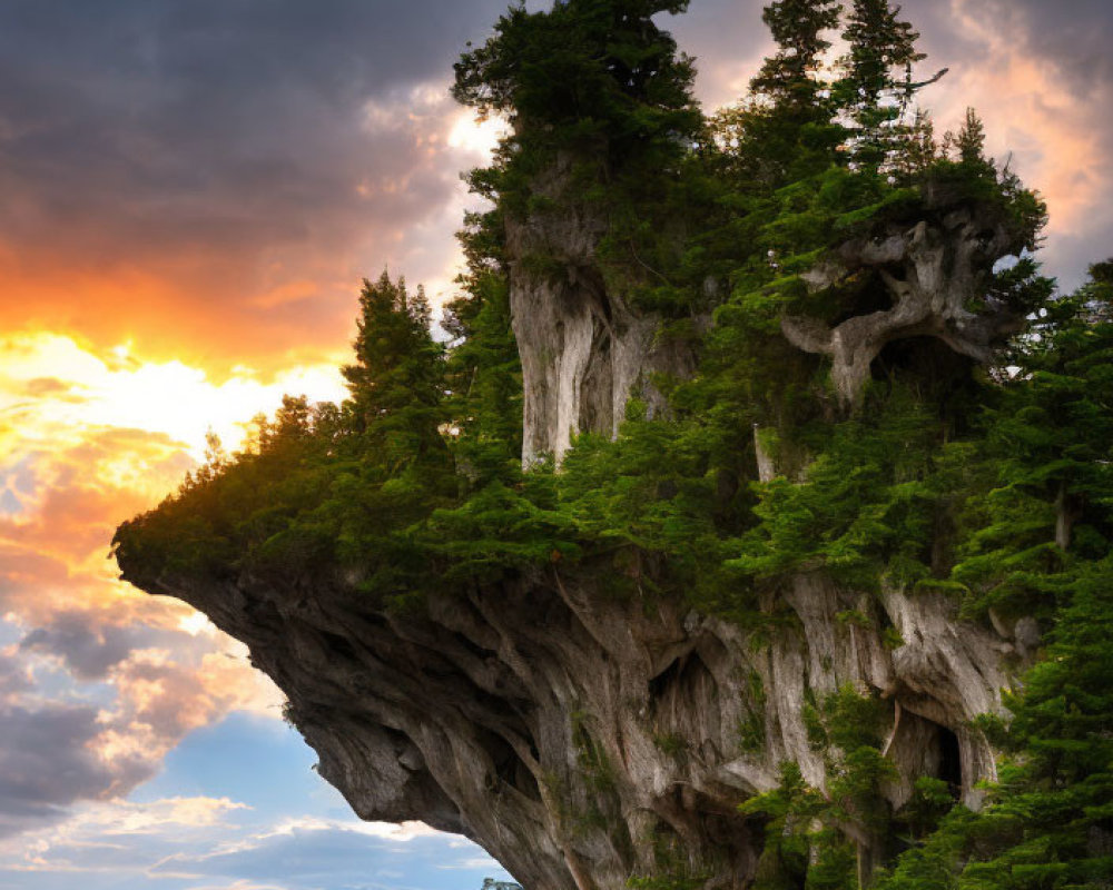 Scenic sunset view of cliff, trees, and mountains with sunbeams.