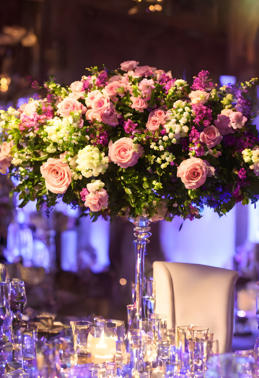 Opulent pink and white flower centerpiece with candles in elegant setting