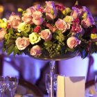 Opulent pink and white flower centerpiece with candles in elegant setting