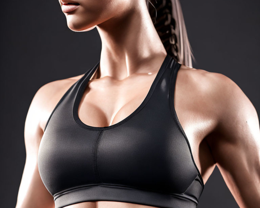 Fit woman in black sports bra showcasing toned physique and strength