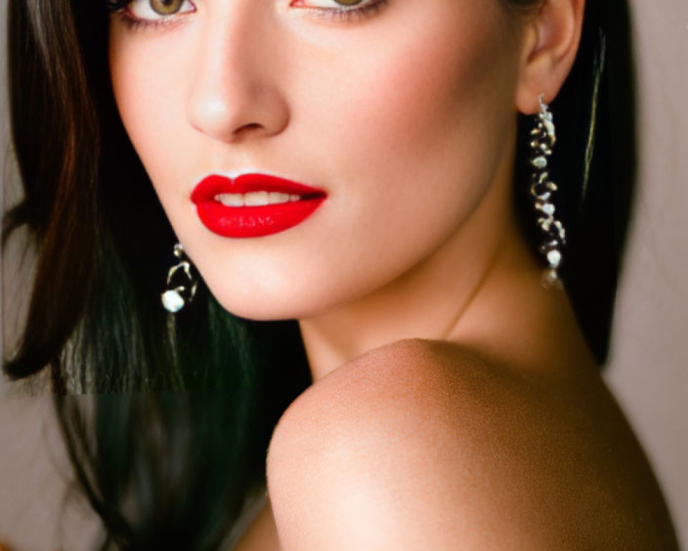 Portrait of woman with dark hair, red lipstick, and earrings.