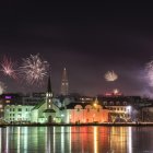 Futuristic night cityscape with skyscrapers, people by water, and glowing orbs