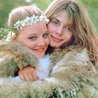 Women with elaborate white and golden hair embracing with a serene white cat in arms surrounded by green foliage and