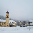 Stylized village scene with snowy patterns and cloudy sky