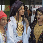 Elegantly Dressed Women in Ornate Hats and Shawls