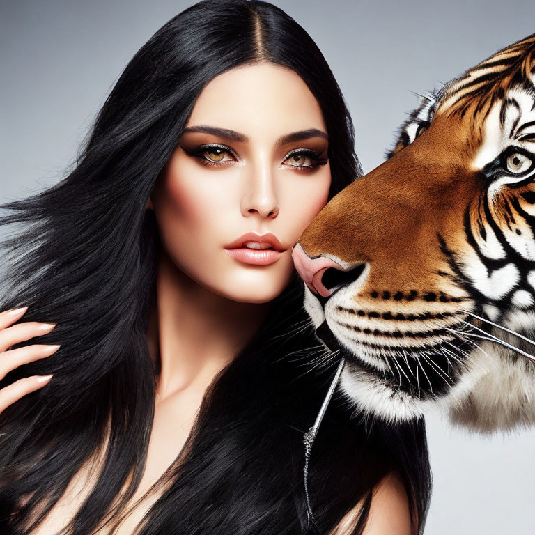 Dark-haired woman with bold makeup close to a tiger's nuzzle.