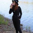 Man with Afro Hairstyle Singing Lakeside in Stylish Black Outfit