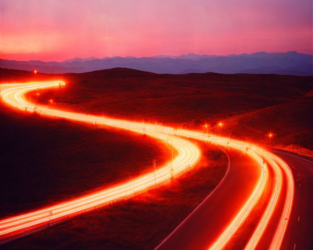 Winding highway at dusk under vibrant pink and purple sky