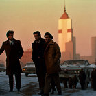 Three men in coats at urban crosswalk with vintage cars and sunset backdrop.