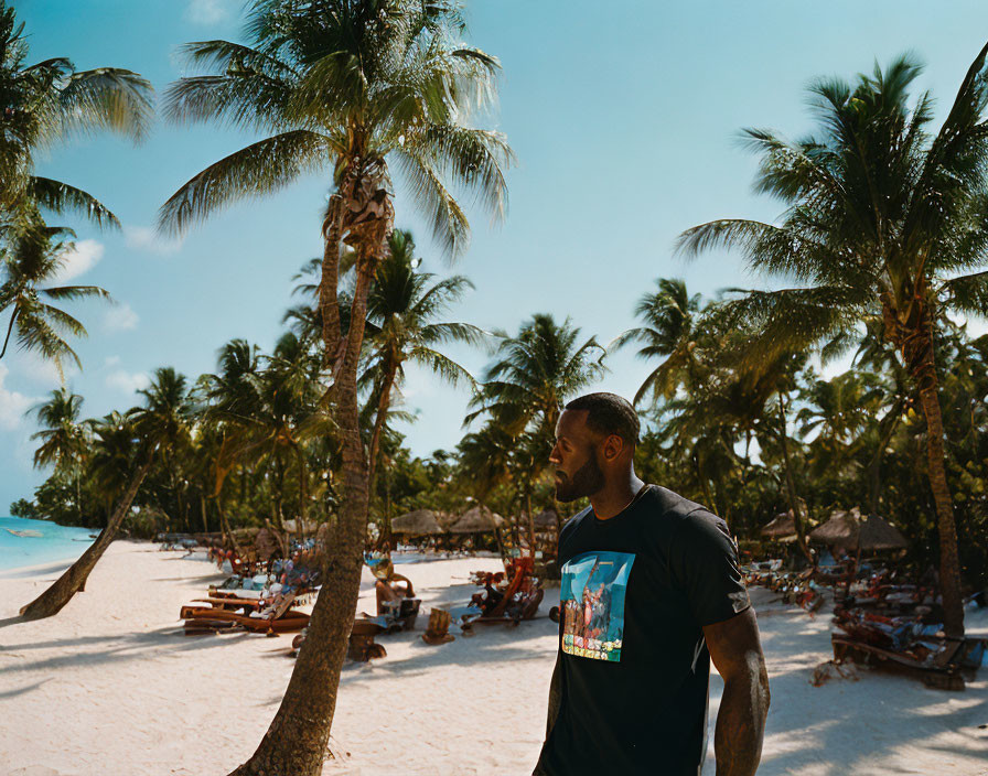 Man in Black T-Shirt Observing Sunny Beach Scene