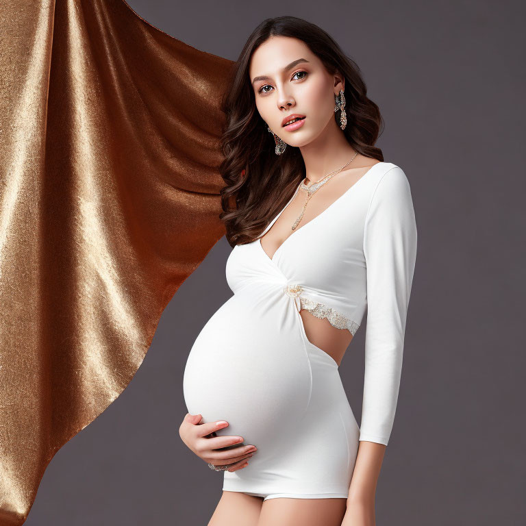 Pregnant Woman in White Dress with Gold Fabric Backdrop and Jewelry