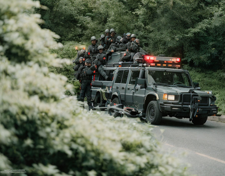 Armed Law Enforcement Officers in Tactical Gear on Armored Vehicle Amid Greenery