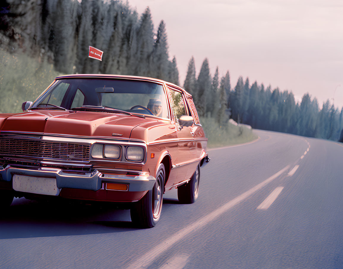 Vintage Red Car Driving on Curved Road with Green Hills