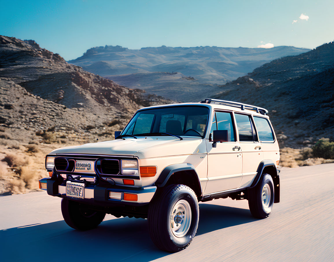 Beige SUV parked on desert road with mountains and clear blue sky