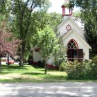 Tranquil church in lush landscape with river and clear sky