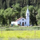 Serene white chapel in lush green landscape