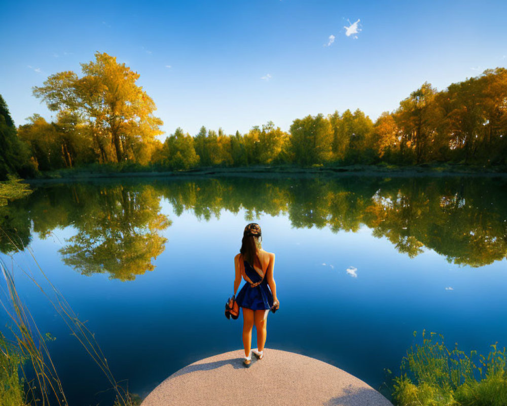 Woman in Blue Dress on Jetty Overlooking Tranquil Lake