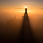 Misty Landscape with Ancient Spires in Golden Sunrise