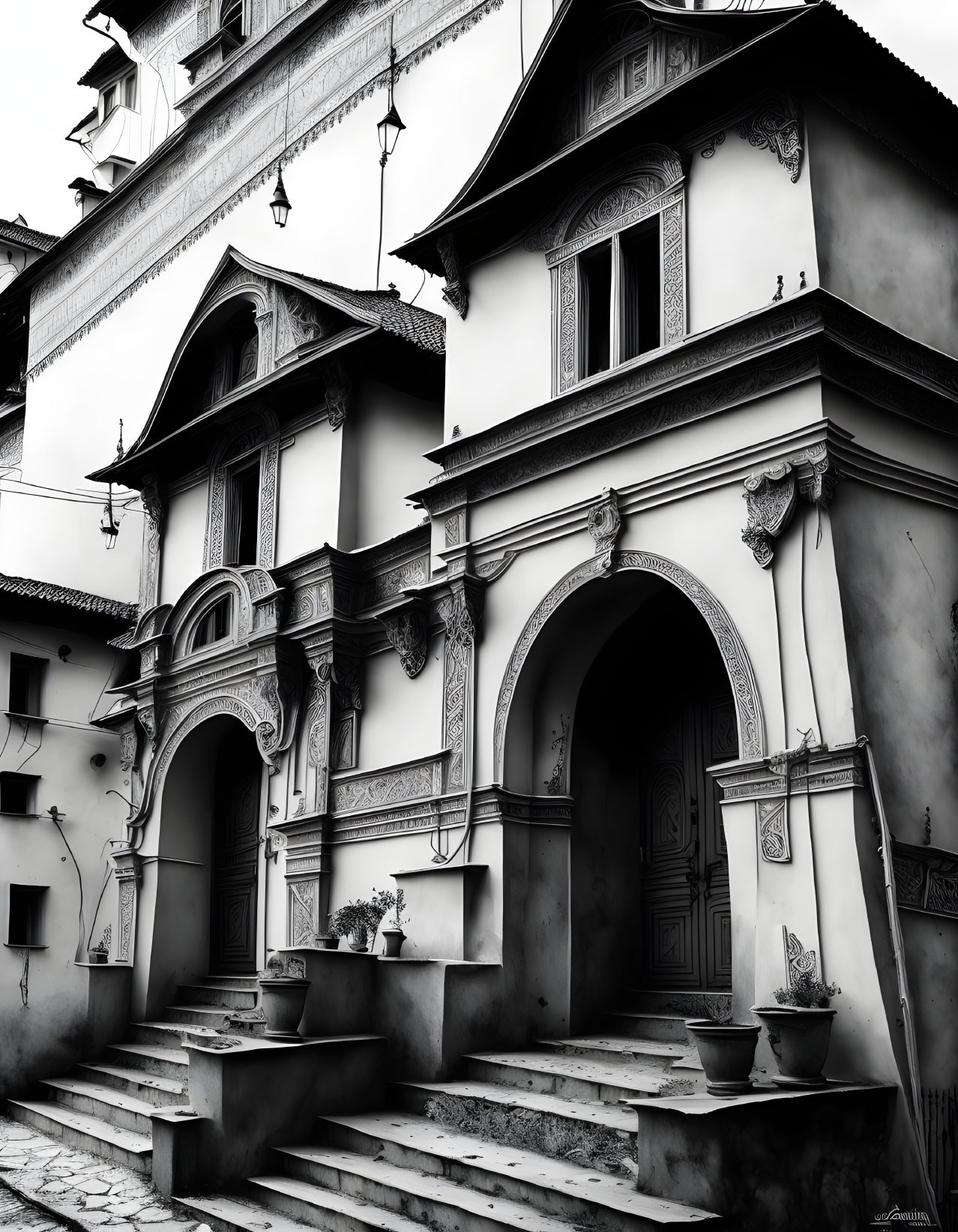 Traditional black and white photo of ornate building with arches and staircases