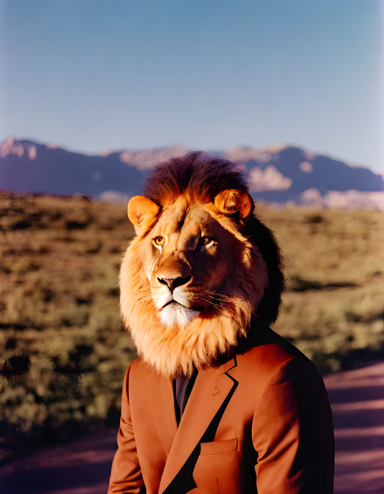 Surreal lion-headed figure in suit against mountain backdrop