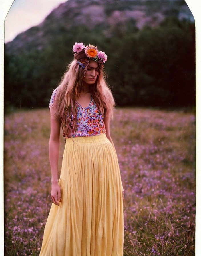 Woman in flowery headband and yellow skirt among purple flowers with hill at dusk