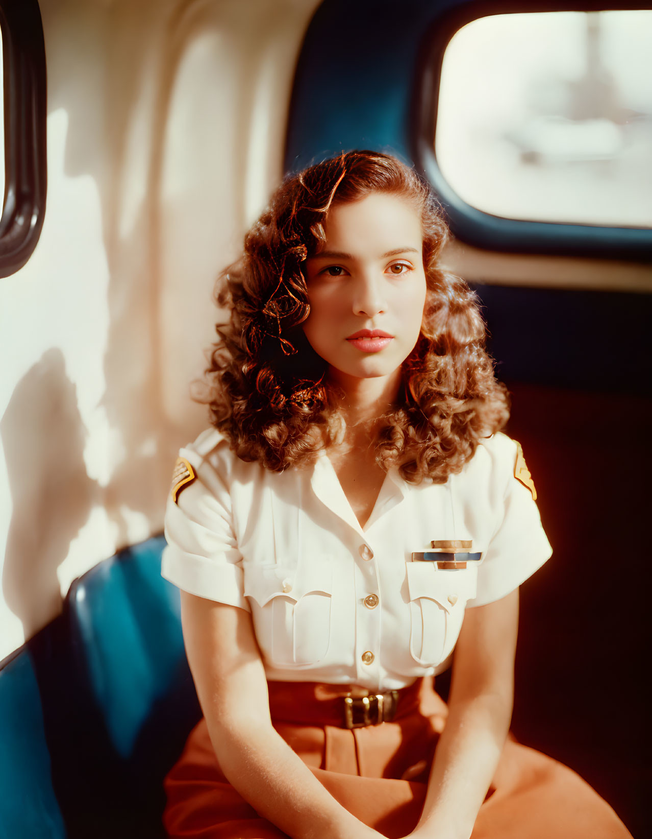 Vintage Portrait of Woman with Curled Hair in Military-Style Uniform in Sunlit Vehicle