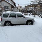 Classic Car in Snowy Scene with Round Windows and Christmas Decorations