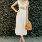 Vintage-inspired woman in puffy-sleeved blouse and striped skirt with leather bag