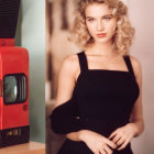 Blonde woman in black outfit poses by vintage photo booth