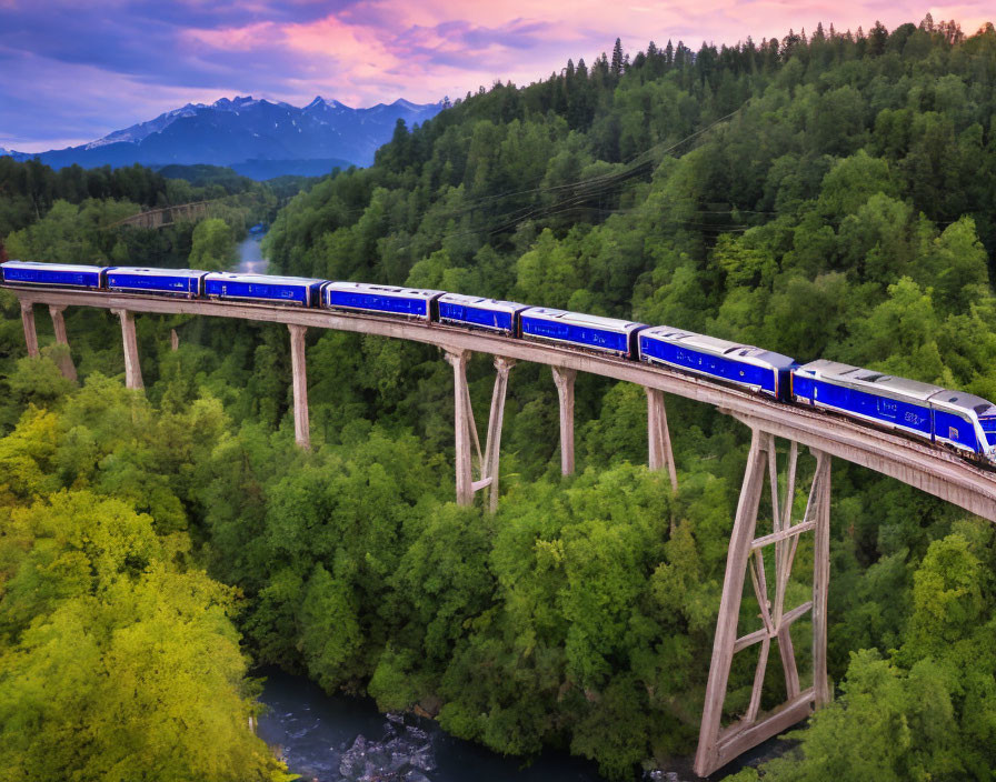 Blue train on tall bridge surrounded by lush greenery and mountains at twilight