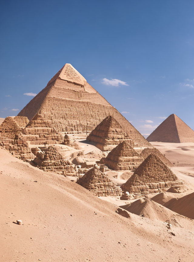 Iconic Great Pyramids of Giza in Egypt with clear blue sky and surrounding desert landscape.