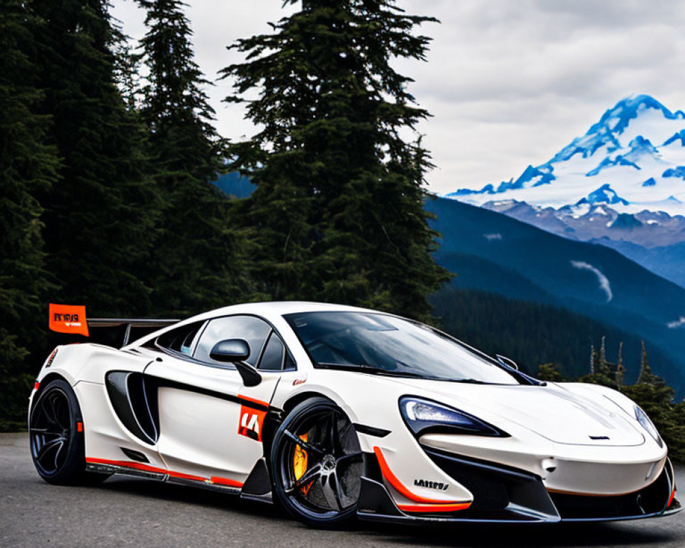 White McLaren sports car with orange and black accents against mountain backdrop.