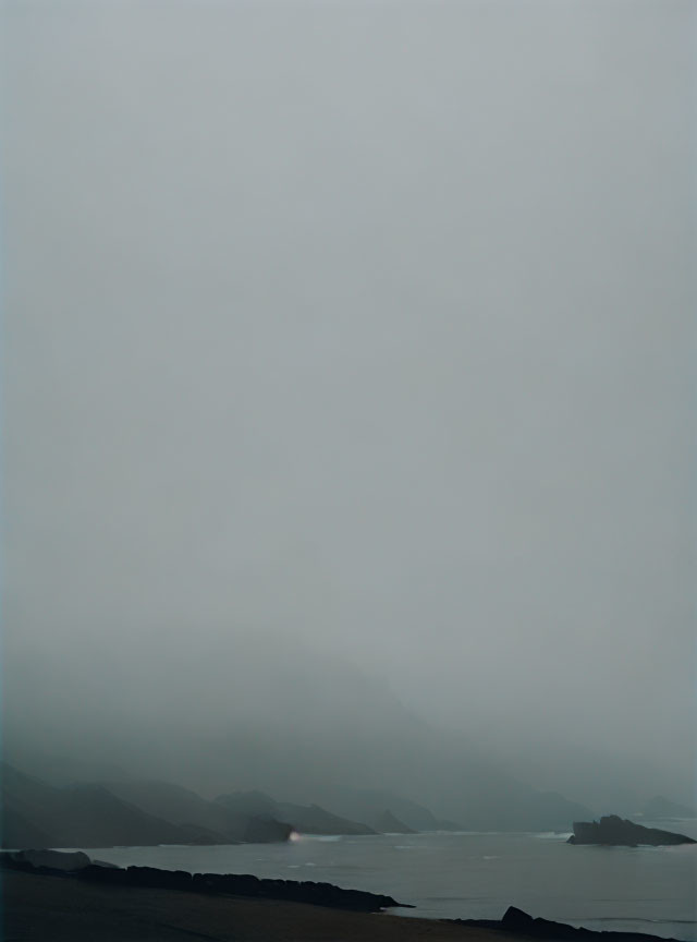 Misty seascape with shadowy mountains and subtle light