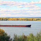 Autumn river landscape with boats, dock, and colorful trees