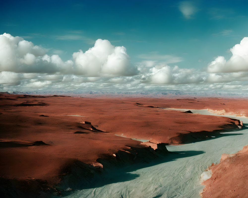 Tranquil desert scene: red sand dunes, blue sky, white clouds, and winding river