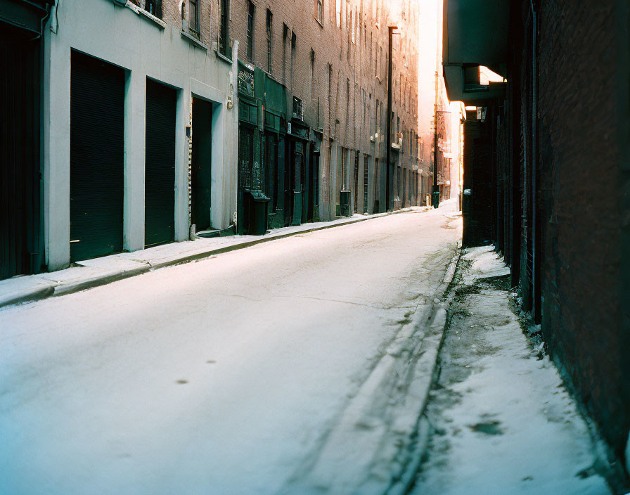 Winter scene: Snowy alley, buildings, glowing light.