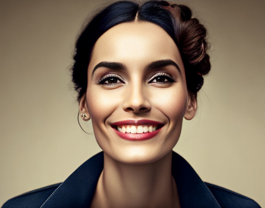 Woman with Updo Hairstyle and Bright Smile Against Neutral Background