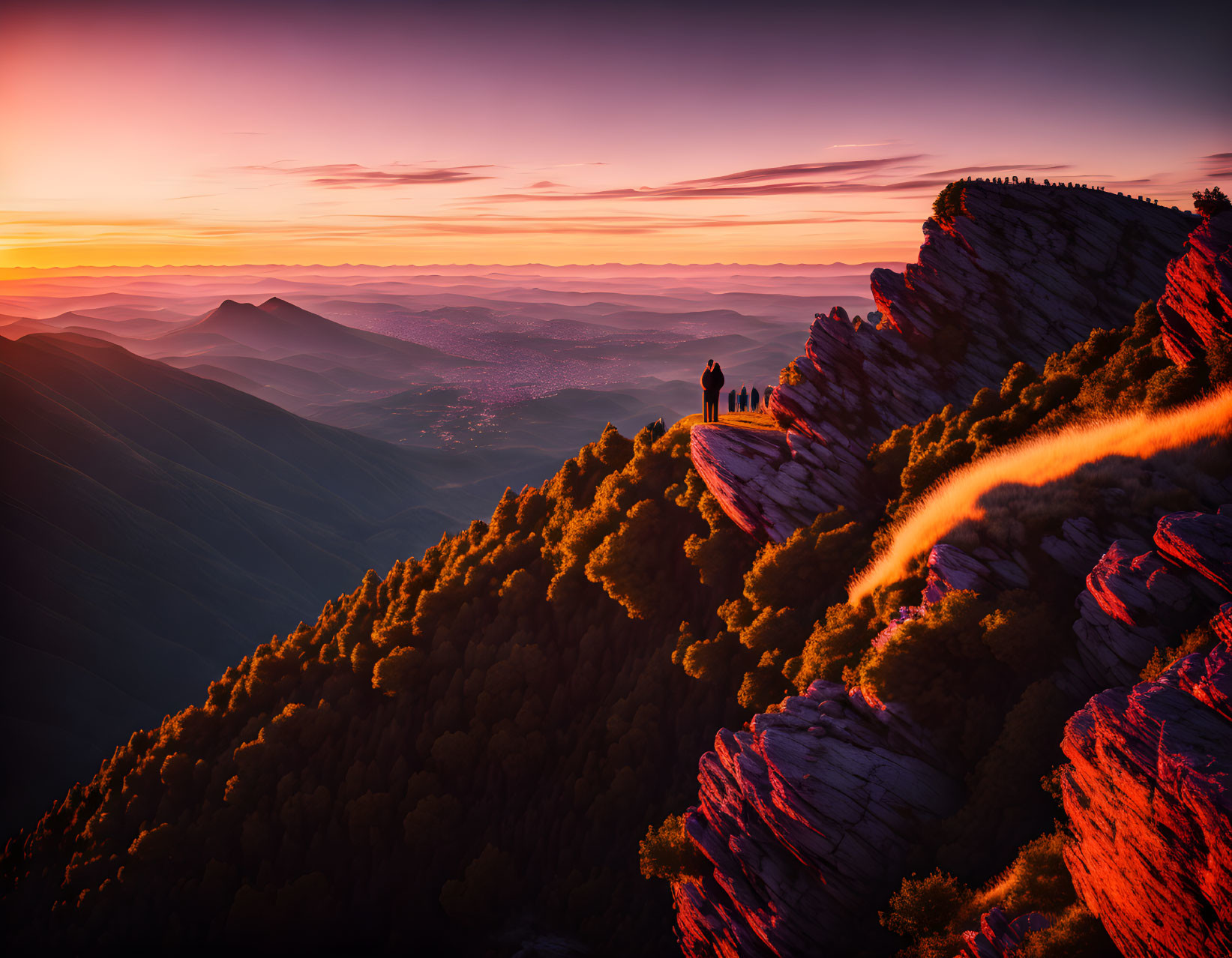 Colorful Sunset Silhouettes on Mountain Cliff Edge