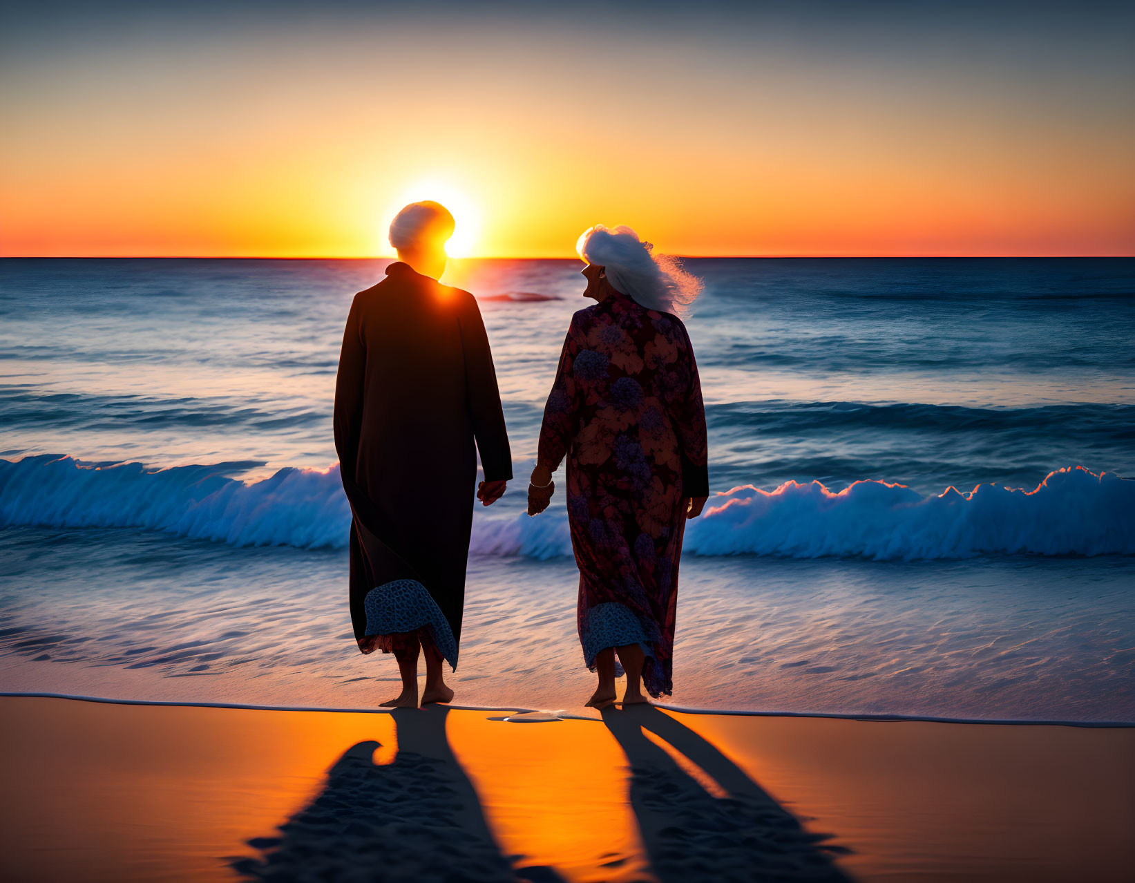 Couple holding hands on beach at sunset with elongated shadows