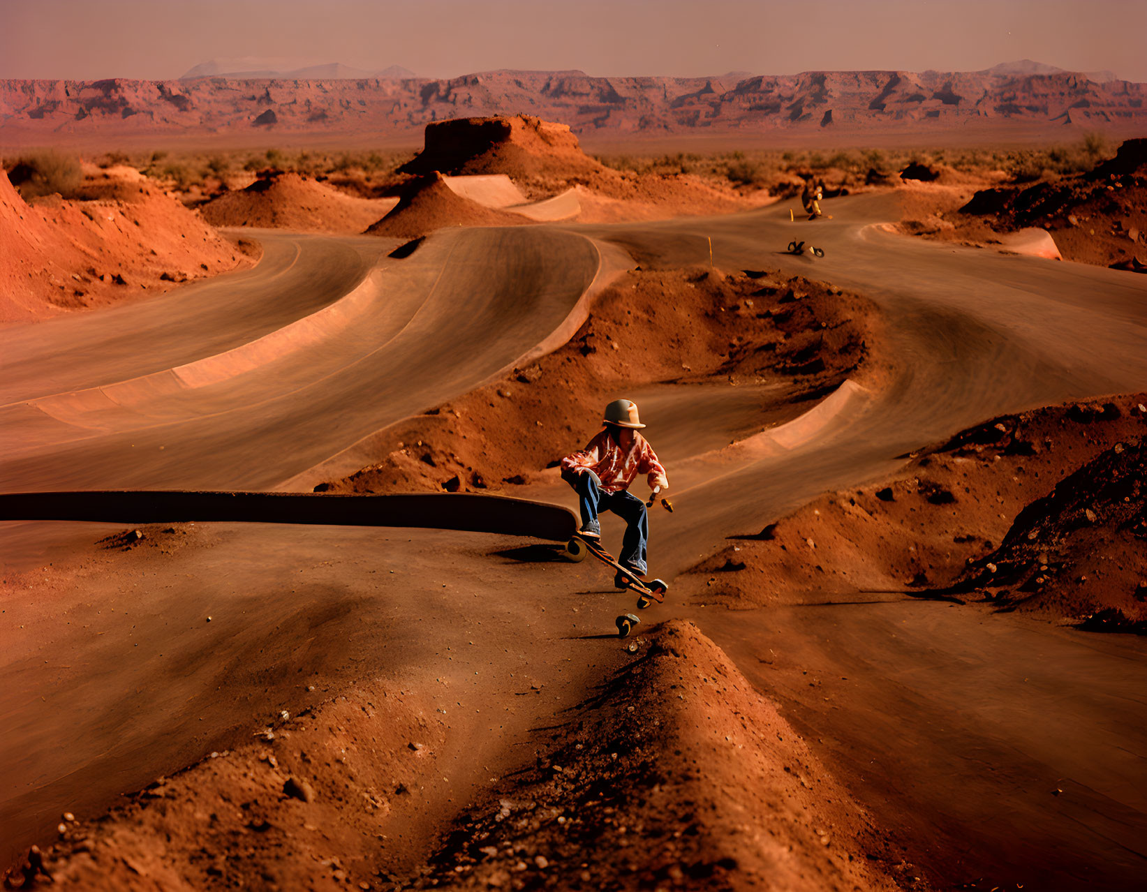 Skateboarder on winding desert road under clear sky